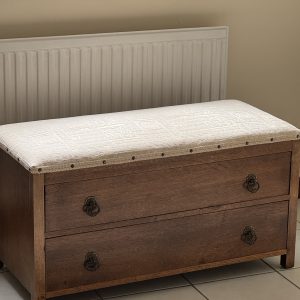 Vintage storage bench with drawers and an upholstered top.