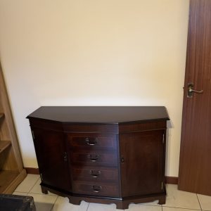 An antique mahogany bowfront sideboard with inlaid banding and brass hardware.